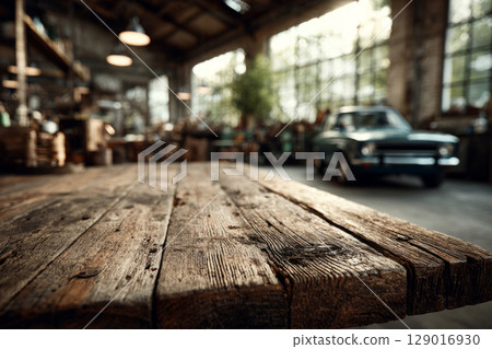 Wooden table in front of vintage car inside rustic garage 129016930