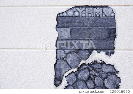 A mural painted so that the bricks inside can be seen when it crumbles 129016950