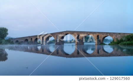 Ancient Bridge Over Misty River, Mystical Journey, Historic Crossroads, Timeless Passage. Perfect for historical travel, fantasy themes, philosophical concepts Ancient Bridge Over Misty River, Mystical Journey, Historic Crossroads, Timeless Passage. Perfect for historical travel, fantasy themes, philosophical concepts 129017560