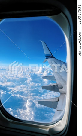 Airplane Window View, Clouds, Horizon, Serene Journey. Great for travel blogs, inspirational content, mindfulness, vertical shot Airplane Window View, Clouds, Horizon, Serene Journey. Great for travel blogs, inspirational content, mindfulness, vertical shot 129017631