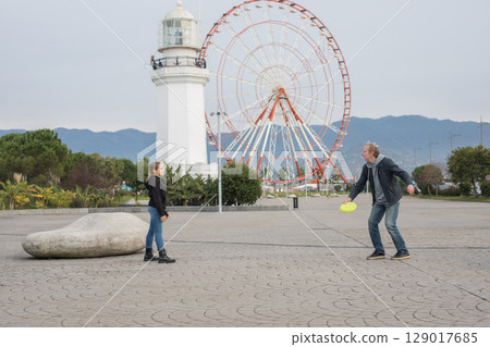 Family together. Father and daughter playing flying disc and having fun outdoors. Happy family Family together. Father and daughter playing flying disc and having fun outdoors. Happy family 129017685