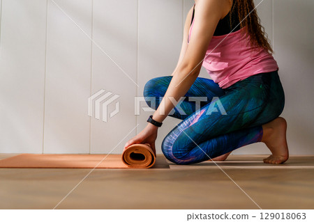 woman is rolling yoga mat 129018063