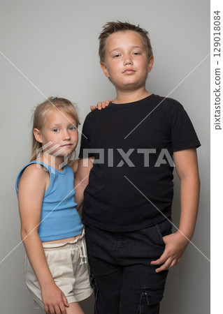 Portrait of siblings, brother and sister hugging and posing over white background 129018084