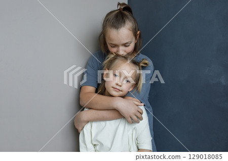 Little young sister and brother hugging indoor. Sibling children together portrait 129018085