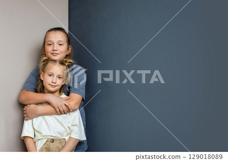 Happy young sister and brother hugging indoor. Sibling children together portrait 129018089