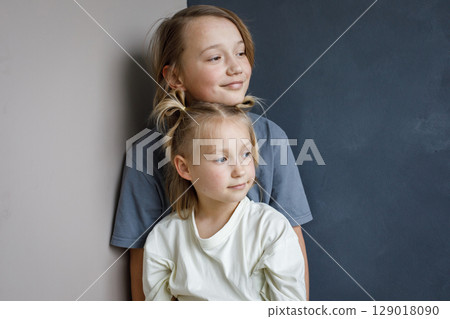 Smiling young sister and brother hugging indoor. Sibling children together portrait Smiling young sister and brother hugging indoor. Sibling children together portrait 129018090