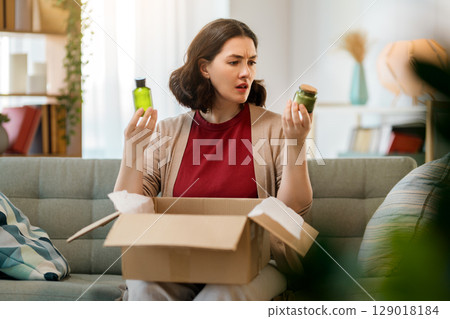 Woman is unpacking cardboard Woman is unpacking cardboard 129018184