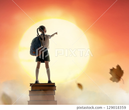 child on the tower of books 129018359