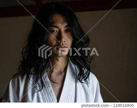 A young man with long black hair wearing a white kimono 129018400