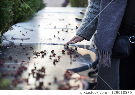 Touching a Cold Marble Surface Scattered With Leaves During a Serene Afternoon in a Garden 129018579