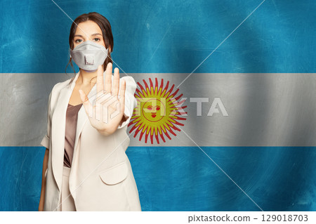 Confident woman in medical mask showing stop gesture open palm hand Confident woman in medical mask showing stop gesture open palm hand 129018703