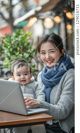 Mother working with baby outdoors 129018711