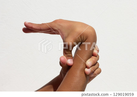 Child demonstrating thumb flexibility by bending it toward his arm Child demonstrating thumb flexibility by bending it toward his arm 129019059