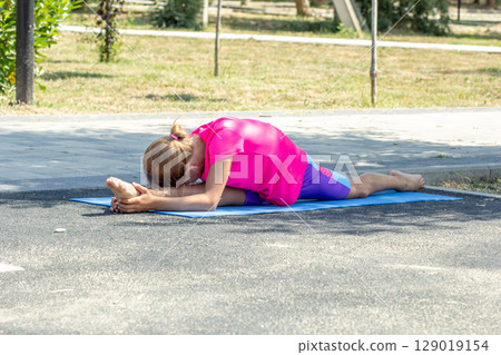 Child lying forward in a front split stretch 129019154