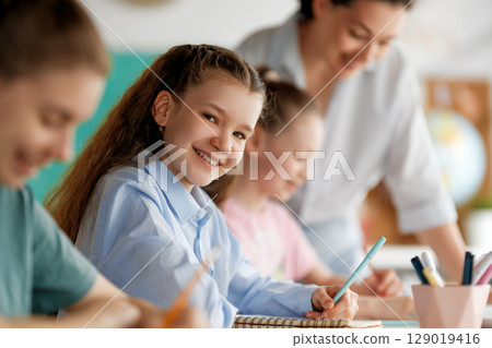 Happy kids and teacher at school 129019416