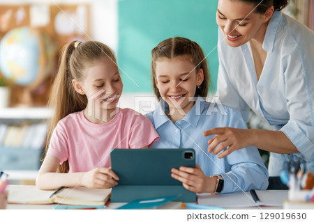 Happy kids and teacher at school Happy kids and teacher at school 129019630