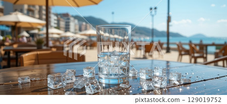 Glass of Ice Water on a Seaside Restaurant Terrace Sunny Day 129019752