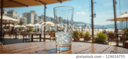 Empty Glass with Ice on a Bright Seaside Terrace 129019755
