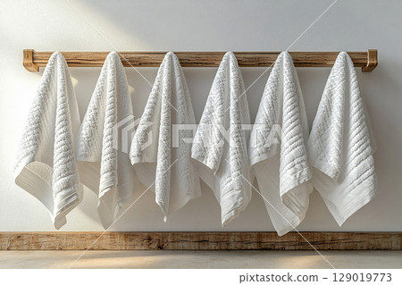 Line of freshly washed white towels hanging on a rack in Rocco Renaissance style. 129019773