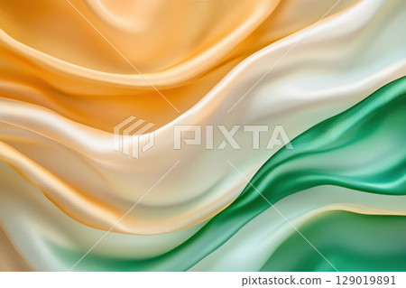 Translucent fabric layers in golden and emerald green colors gently flowing under soft natural light 129019891