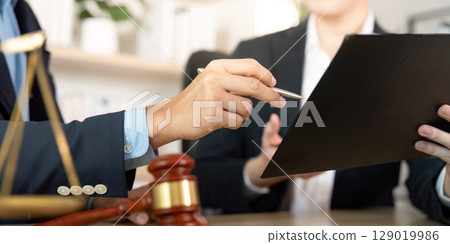 Legal Discussion. Lawyer pointing at document during client consultation. Legal Discussion. Lawyer pointing at document during client consultation. 129019986