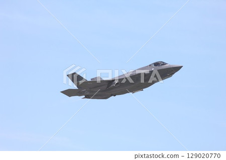 A US Air Force F-35A Lightning II stealth fighter jet flying in a clear blue sky 129020770