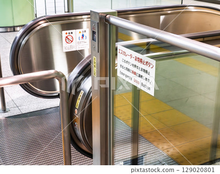 Emergency stop button and warning sign on an escalator 129020801