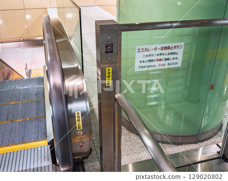 Emergency stop button and warning sign on an escalator Emergency stop button and warning sign on an escalator 129020802