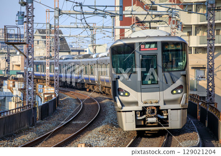 A 225 series train running on a curve near Teradacho Station on the Osaka Loop Line 129021204