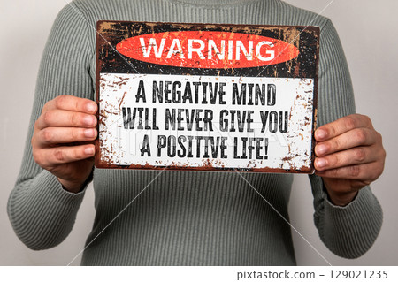 Warning Sign with Motivational Quote About Mindset and Positive Thinking Held by Person Warning Sign with Motivational Quote About Mindset and Positive Thinking Held by Person 129021235
