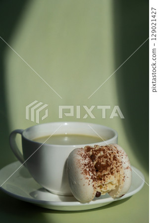 Sweet macaron dessert Cup of green plant based matcha tea latte in cozy morning atmosphere. Creative holiday romantic date idea. Herbal prebiotic fiber superfood beverage antioxidant-rich immunity Sweet macaron dessert Cup of green plant based matcha tea latte in cozy morning atmosphere. Creative holiday romantic date idea. Herbal prebiotic fiber superfood beverage antioxidant-rich immunity 129021427