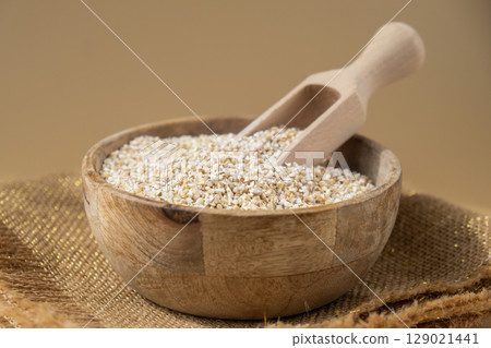 Fine ground barley in neutral beige background. Whole spelt grain species. High protein fiber-rich vegan plant based food ingredient. Gluten free superfood healthy nutritional dietary alternative 129021441