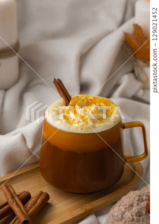 Pumpkin spiced latte morning warming coffee. Fall Drinks for Halloween Thanksgiving Holiday beverage Autumn spicy cinnamon flavor seasonal hot drinking in cozy orange cup. Atmosphere of cold rainy 129021452