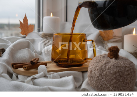 Seasonal drink cacao coffee with whipped cream and cinnamon sticks Thanksgiving and Hello Fall Halloween concept. Celebrating autumn holidays at cozy home on the windowsill atmosphere Autumn leaves 129021454