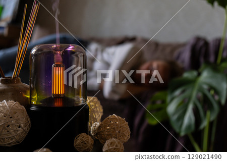Indoors Decoration with modern lighted Air Humidification Aroma essential oil perfume fragrance. Scented home wellness wellbeing habit. Concept of feeling good spiritual health 129021490