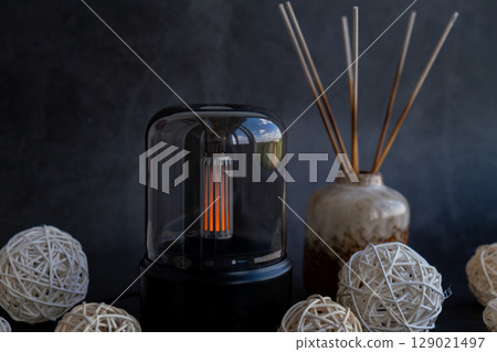 Close up of home perfume scent air humidifier with light. Aromatherapy holistic health practices concept. Stress relief activities preparing for meditation. Simple pleasures healing 129021497
