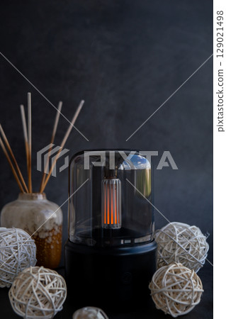 Indoors Decoration with modern lighted Air Humidification Aroma essential oil perfume fragrance. Scented home wellness wellbeing habit. Concept of feeling good spiritual health 129021498