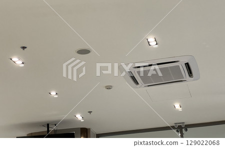 White ceiling with modern air conditioner system for ventilation and cooling. Interior space with recessed lighting technology. clean and comfortable atmosphere for an office 129022068