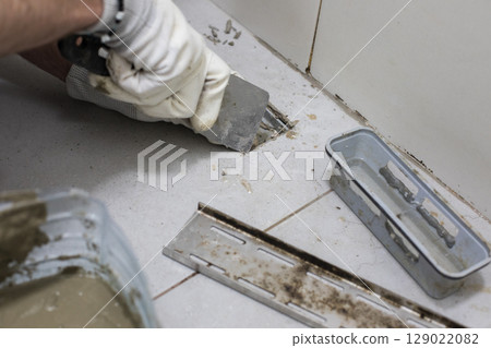 Worker repairs sewer and bathroom drain 129022082