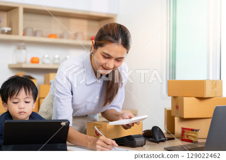 Working Parent Balancing Business and Family with Child at Home Office 129022462