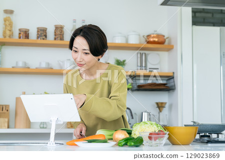 Middle-aged woman cooking in the kitchen 129023869
