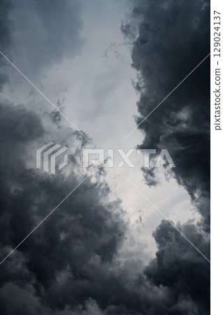 Vertical photo of dark gray storm clouds before rain. Storm, darkness, death. Perfect photo for nature, climate, weather, drama and emotional background concepts. Vertical photo of dark gray storm clouds before rain. Storm, darkness, death. Perfect photo for nature, climate, weather, drama and emotional background concepts. 129024137