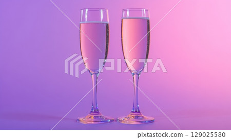 two champagne flutes on purple background 129025580