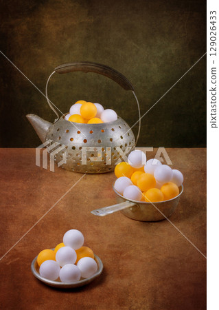 Still life with aluminum teapot and white and orange balls Still life with aluminum teapot and white and orange balls 129026433