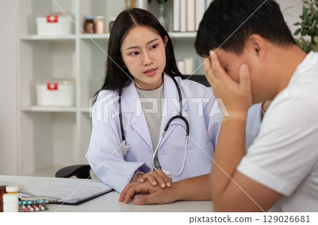 Healthcare Consultation. Doctor providing emotional support to male patient in medical office. 129026681