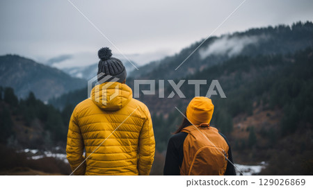 Couple tourists enjoying mountain view in foggy weather, ideal for travel content Couple tourists enjoying mountain view in foggy weather, ideal for travel content 129026869