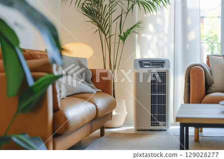 Modern living room is being cooled by a portable air conditioner, creating a comfortable atmosphere 129028277