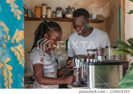 Two African baristas smiling and preparing a cup of coffee with a professional machine 129028345