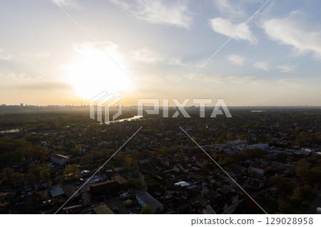 Captivating Aerial View of a Cityscape Bathed in Golden Sunset Light, Showcasing the Harmony of Urban Life and Nature at Dusk 129028958