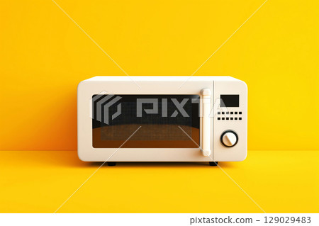 White microwave oven standing on a yellow background, representing modern kitchen appliances and minimalist interior design 129029483
